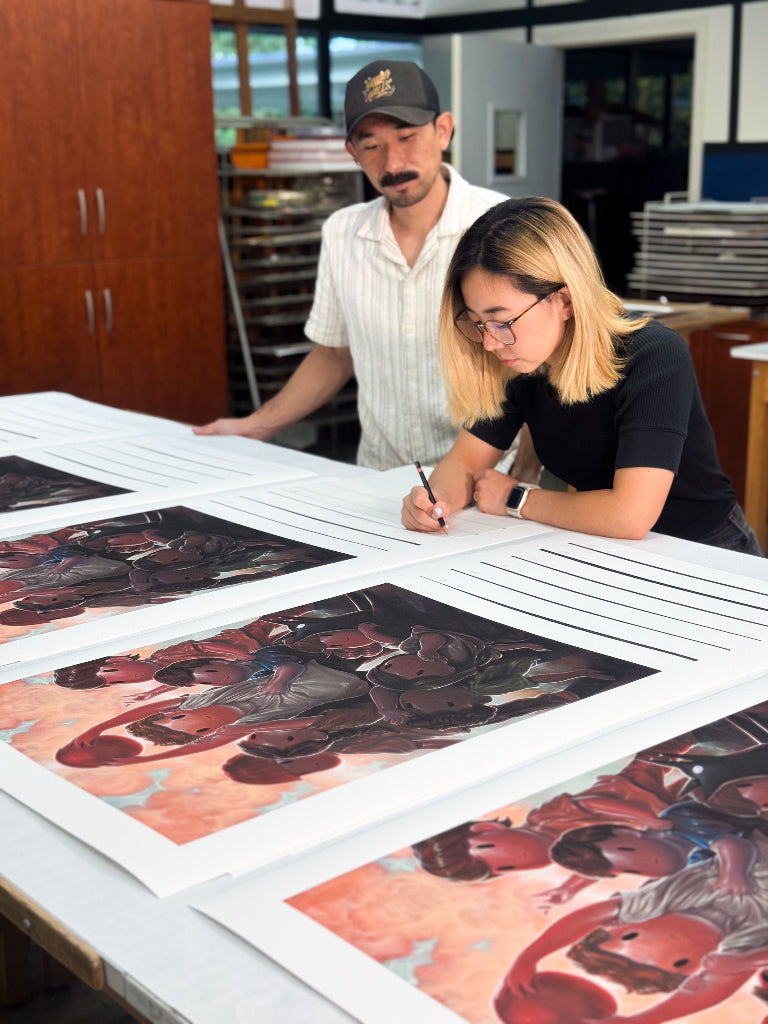 man and woman (Giorgiko) signing prints of children playing dodgeball