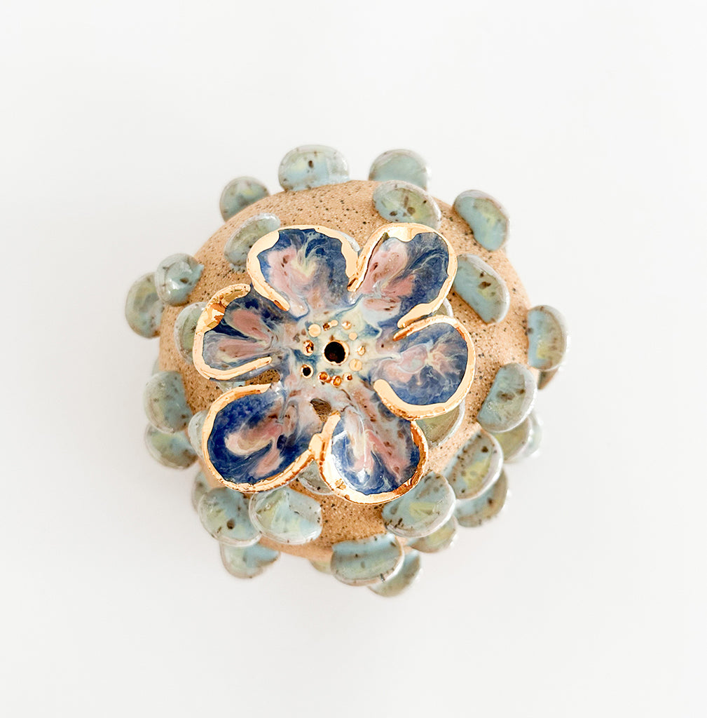 Photograph of a ceramic floral sculpture with multicolor glaze and gilded finish by Jen Dwyer