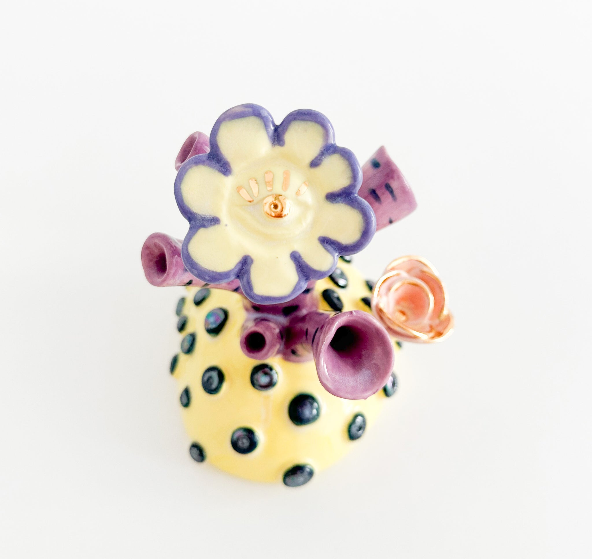 Photograph of an abstract floral sculpture with multicolor glaze and gilded finish by Jen Dwyer