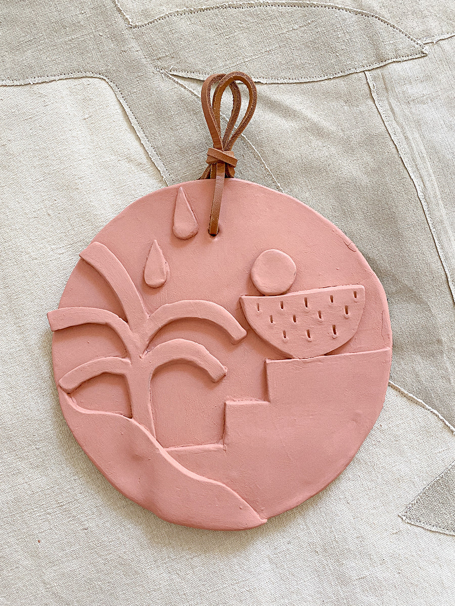flat pink ceramic circle of a tree and other shapes