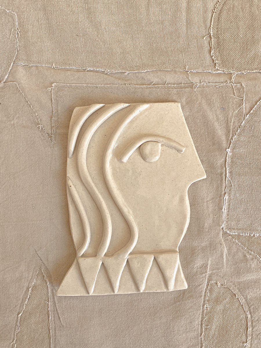 cream ceramic of side profile of a vase
