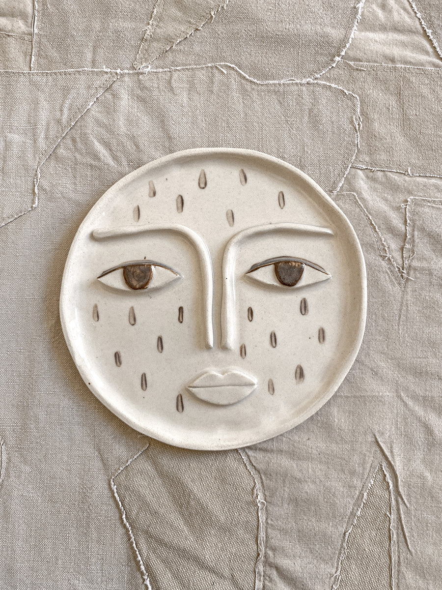 the moon with a face and a droplet pattern made from ceramic clay