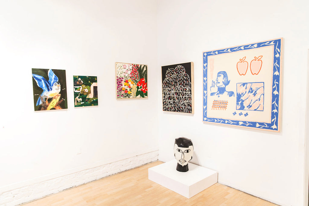 A gallery wall features five vibrant artworks, including Liz Hernandezs Floral Times, showcasing abstract and figurative styles. An acrylic on canvas masterpiece stands out, while a sculpted head rests on a plinth below on the wooden floor. The room, with pristine white walls, is bathed in light.